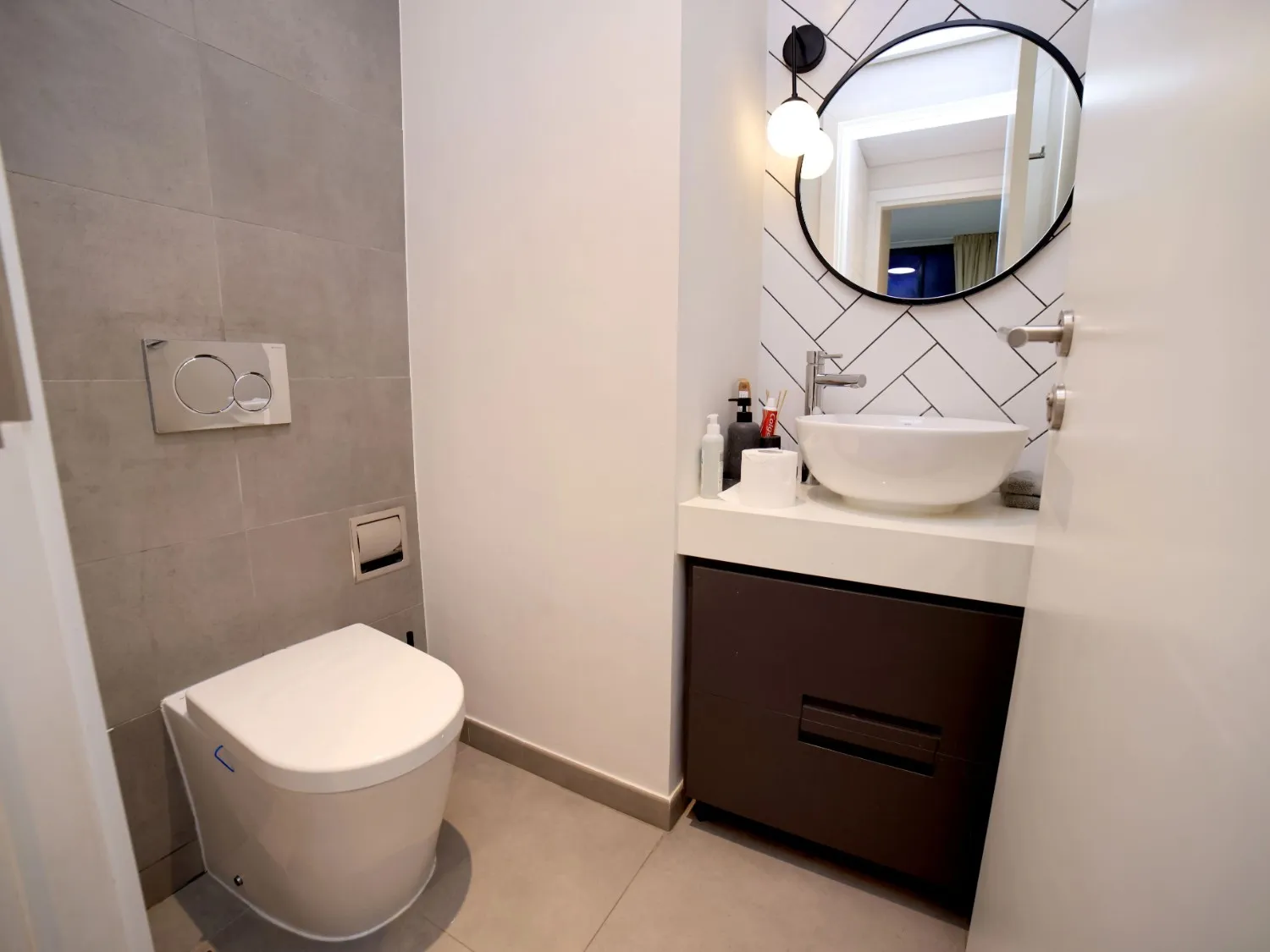 Decorative wall finish and compact vanity featured in a powder room remodel in La Grange, IL.