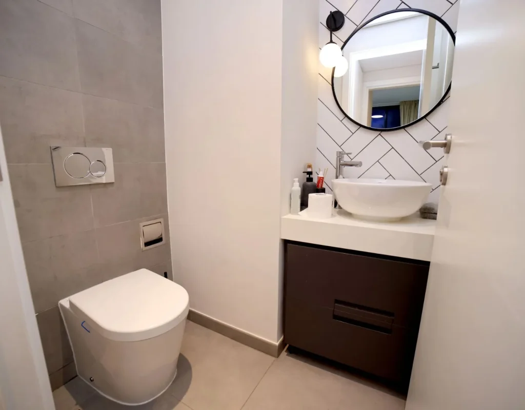 Decorative wall finish and compact vanity featured in a powder room remodel in La Grange, IL.